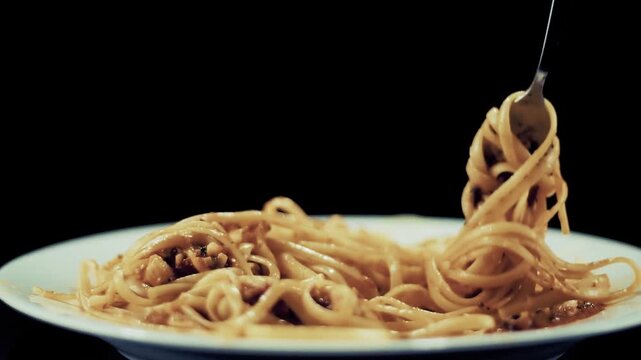 Fork Lifting Spaghetti With Meat Sauce From Plate During Meal