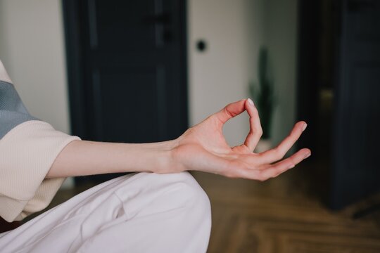 Close-up of a woman's hand forming Gyan mudra during meditation at home, symbolizing mindfulness, inner peace and concentration through yoga, breathing exercises and relaxation
