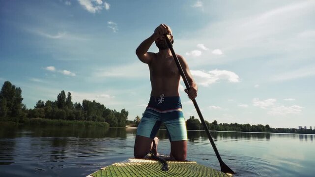 Paddleboarder On Sup Board And Paddling Along Calm River Water On Sunny Summer Day
