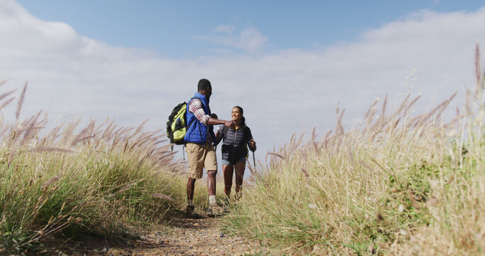 African american couple walking while trekking in the mountains