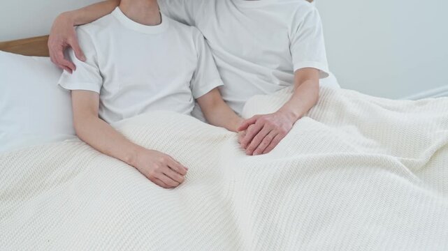 ベッドで寄り添う二人の男性。同性愛、LGBT、恋愛、恋人、パートナー、カップル、ゲイ、同性婚、性自認