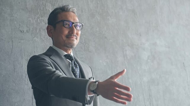 握手を求めるミドル男性ビジネスパーソン。経営、協力、採用、サポート、ビジネス、スカウト、勧誘、営業