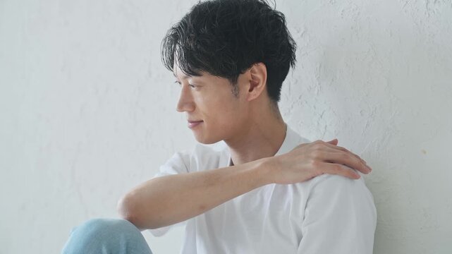 床に座ってリラックスする若い男性。メンズ、美容、ボディケア、スキンケア、エステ、爽やか、イケメン