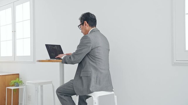 A male business person using a laptop. Keywords: PC, business, work, DX, office, digital, cafe
