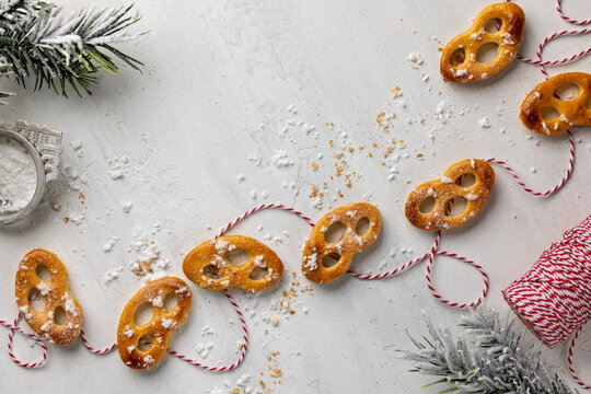 Christmas sweet pretzel cookies arranged with red twine on white background for homemade baking, snack packaging or seasonal food design