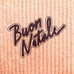 Italian buon natale greeting written in stylized dark brush script on textured copper surface with christmas greetings typography calligraphy celebration metallic background lettering © Ianpylok