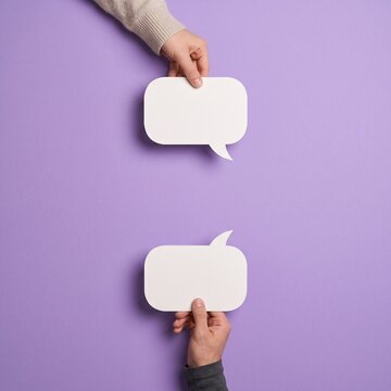speech bubble Two hands holding blank white speech bubbles from top and bottom on lavender purple background with copy space