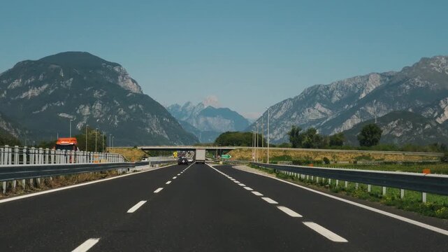 Driving on empty A23 highway passing overhead direction road signs for Villach and Osoppo in Friuli.