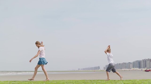 Children with kites are walking through the green seaweed slow motion long distance shot tilt up camera movement