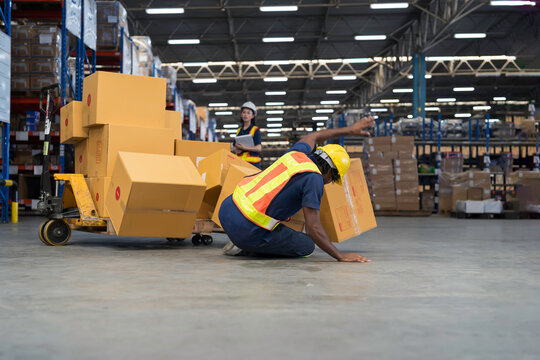 Warehouse worker accident at work. Warehouse worker falling down on concrete floor after cardboard boxes collapsed fell from wooden pallet cart, occupational workplace safety accident concept