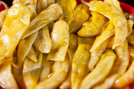 Pickled yellow pepper harvest background. Fermented organic chili pile texture
