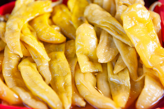 Pickled yellow pepper harvest background. Fermented organic chili pile texture. Salty natural food display