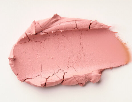Dried pink clay smear with cracked edges on a white background