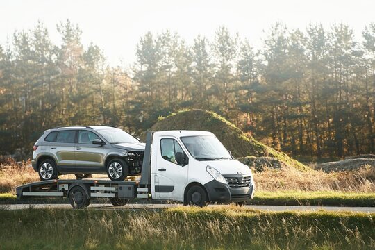 Flatbed truck towing damaged SUV