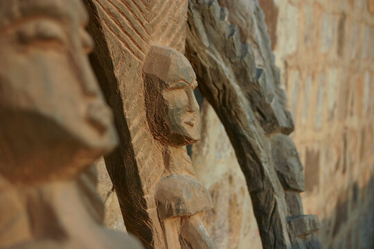Close up of carved Dogon wooden figures against a stone wall, Mopti Region, Bandiagara, Mali
