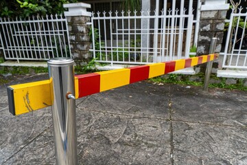 Raised access barrier across a paved vehicle entry © IbragimovN