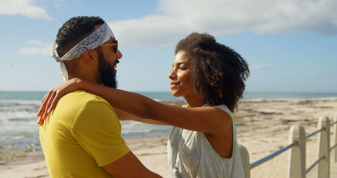 Romantic diverse couple standing and embracing on sunny promenade, copy space