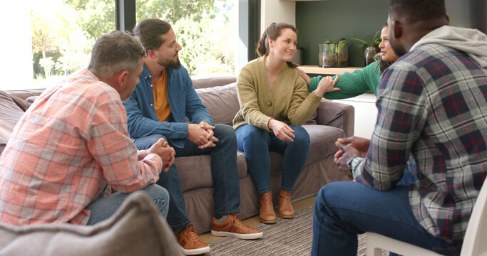 Diverse group of friends talking and supporting each other in group therapy session