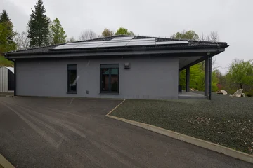 Modular modern smart house exterior in light snowfall with unfinished landscaping and insulation work © .shock