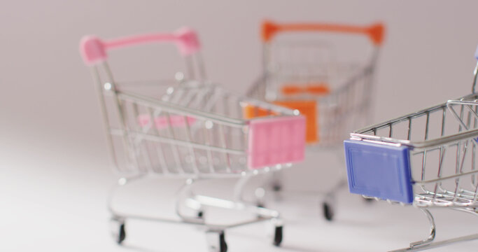 Three empty shopping trollies on grey background