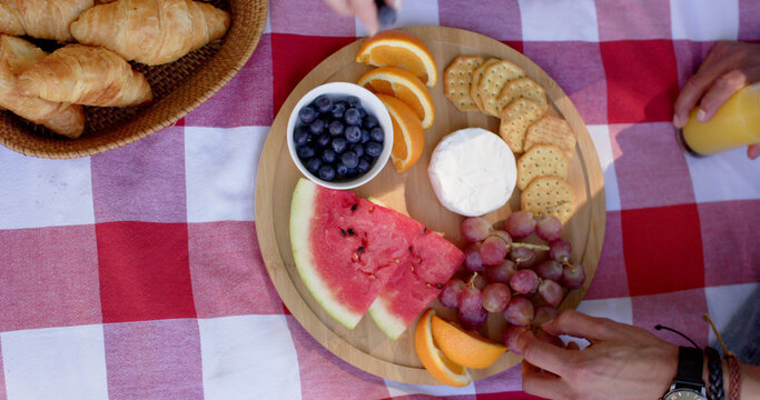 Midsection of diverse couple having picnic in sunny garden