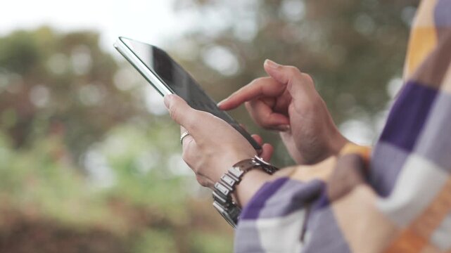 Woman Using Smartphone Outdoors with Natural Green Background in Slow Motion