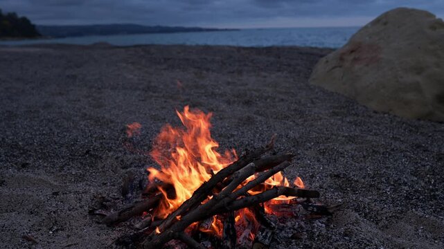Bonfire Burning on Pebble Beach at Dusk with Sea Waves Sound