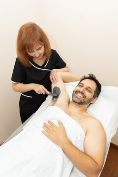 Man getting armpit hair removal waxing treatment