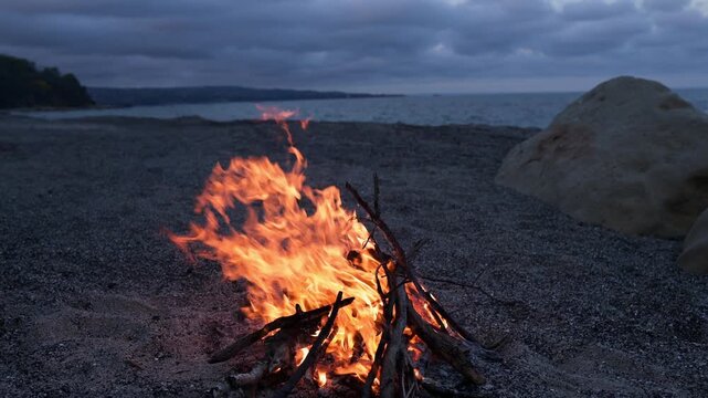 Bonfire Burning on Pebble Beach at Dusk with Sea Waves Sound