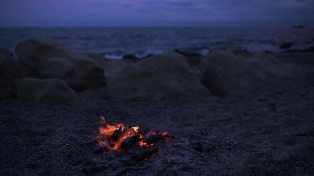 Bonfire Burning on Pebble Beach at Dusk with Sea Waves Sound