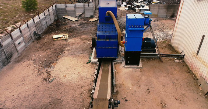 Industrial machinery operates in an outdoor recycling facility