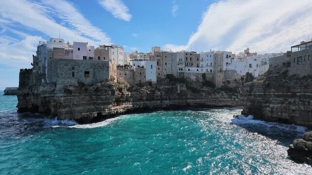 Houses of Polignano a Mare on the limestone cliffs above the turquoise sea, Italy