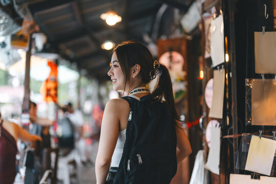 Young adult asian woman traveler enjoy travel choosing souvenir at asia local grocery shop