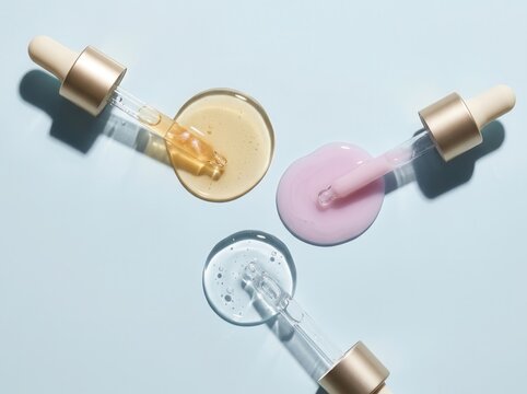 Three types of facial serums, textures on a blue background
