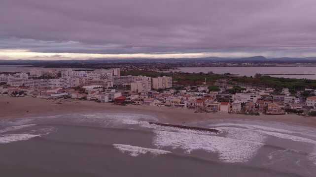 Aerial overview of Carnon beach buildings lagoon and distant city