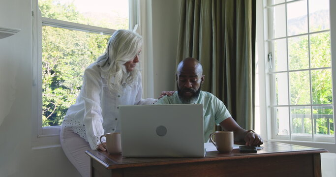 Couple planning wedding day using laptop and smartphone at home, sharing ideas