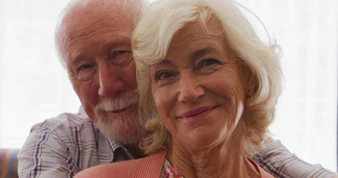 Portrait of a Senior Caucasian couple spending time at home together, embracing, smiling and looking