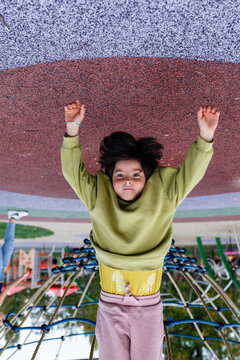 Child Hanging Upside Down on a Playground Rope Climbing Net