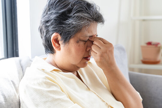 Elderly woman have eyesight problem can not read because seeing text blurred and headache from eye tired.