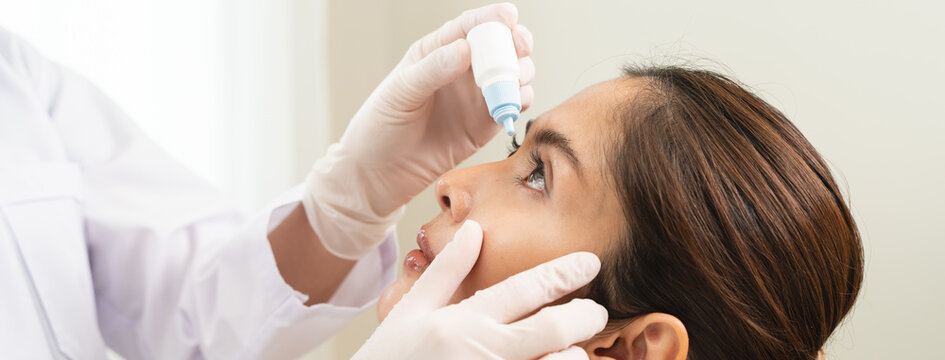 asian young woman using medical eye drops to treat dry eye and irritation.