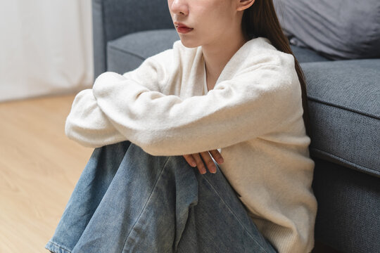 Anxiety young woman sitting on sofa covering her face at home.