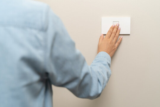 Save energy concept, Close-up person turn off switch off light on the wall