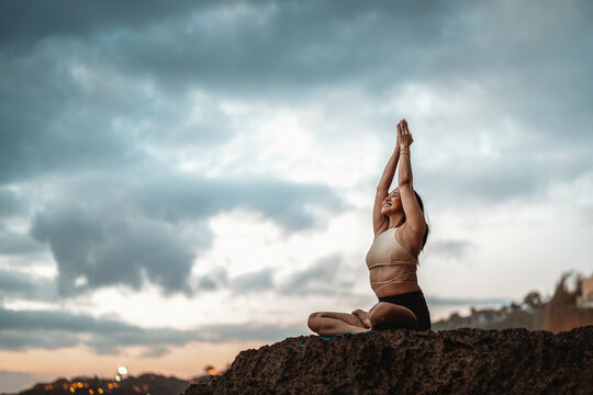 Serene asian woman practicing yoga and mindfulness on a peaceful tropical beach