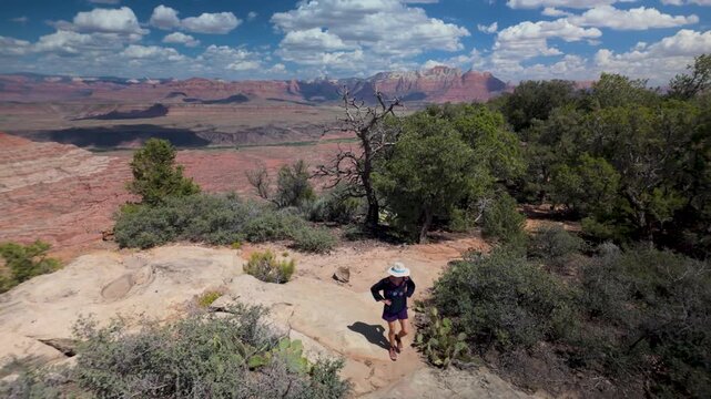 Senior woman enjoys a scenic hike on Gander trail, surrounded by beautiful landscapes of Zion National Park in Utah.