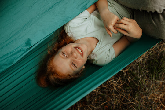 Laughing girl lying in hammock, top view
