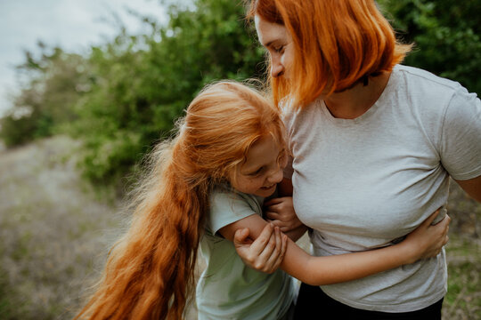 Laughing mother and daughter hugging close-up