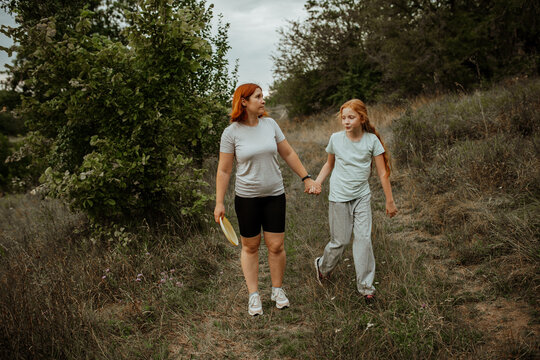 Mother and daughter walking in meadow after game