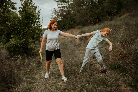 Mother and daughter holding hands and pulling each other playfully