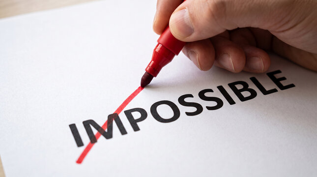 A hand holding a red marker crossing out the word impossible on a white paper, transforming it into possible, isolated on white background