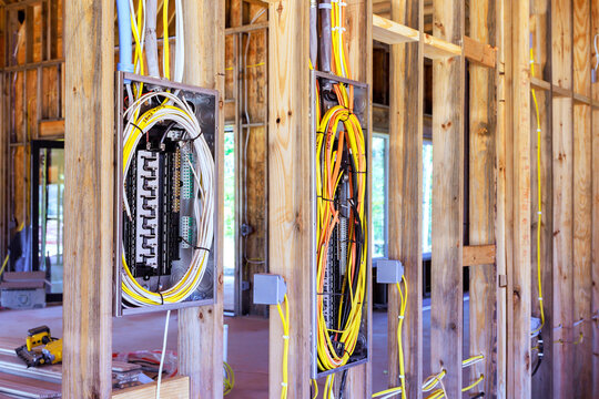 Electricians have routed cables through open timber framing at home construction site